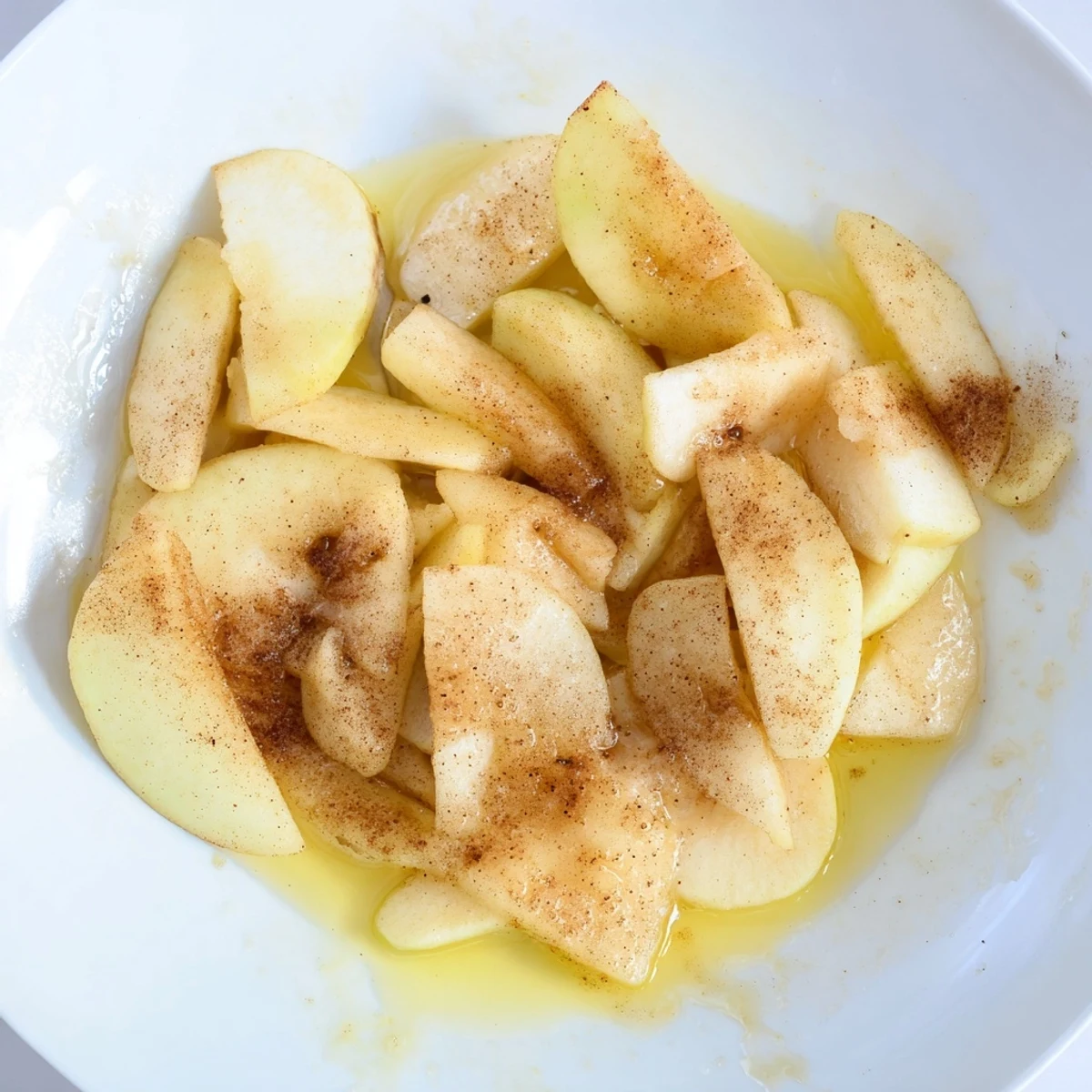 Plump, tender baked apple slices, topped with cinnamon and ready to enjoy with vanilla ice cream.