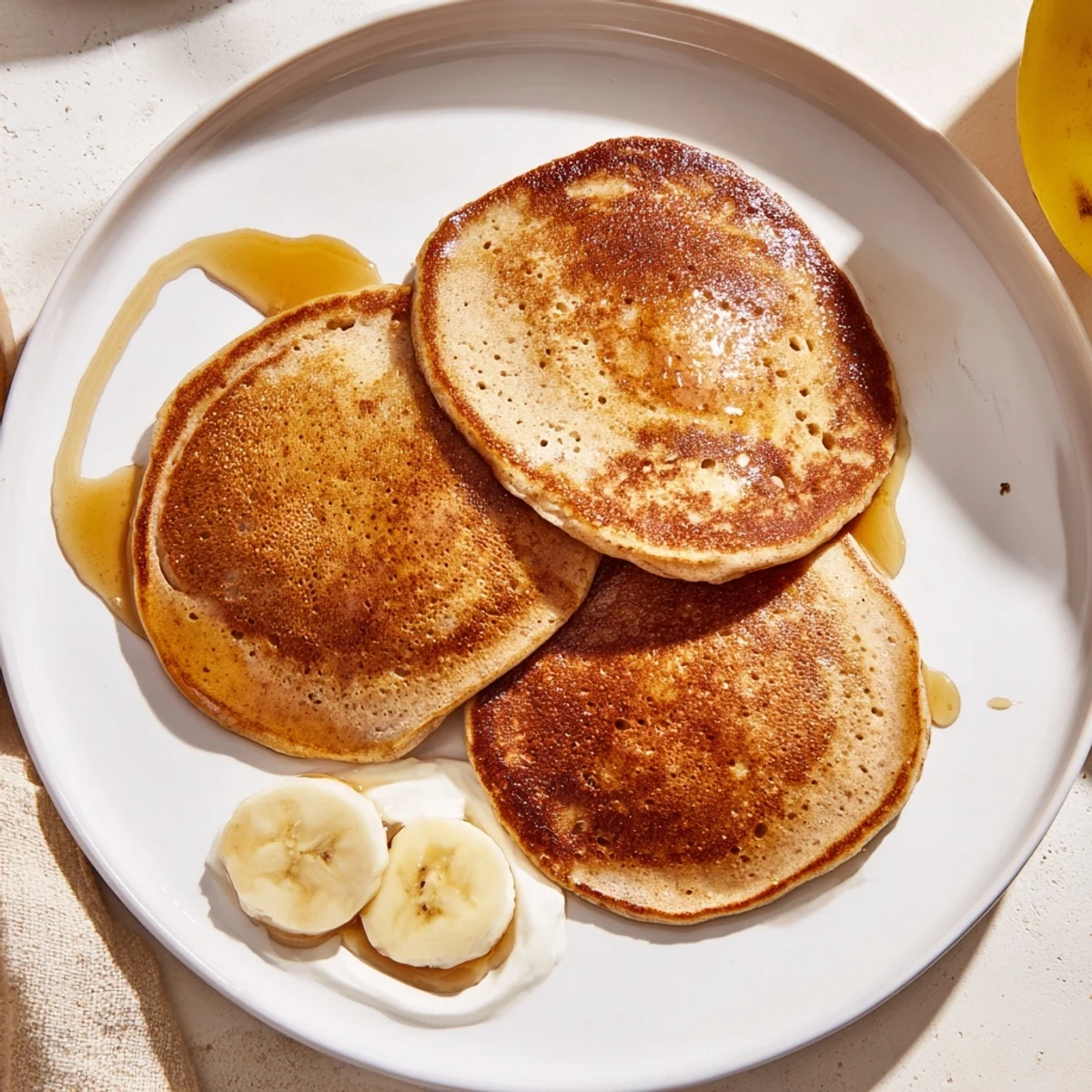 Golden brown Protein Banana Pancakes served with fresh berries, promising a delicious, healthy breakfast.