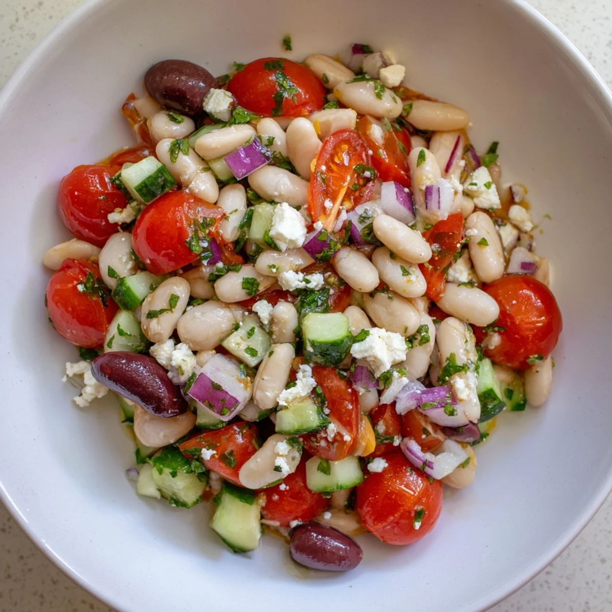 White bean salad bursting with colorful cherry tomatoes and fresh herbs, ready to serve.