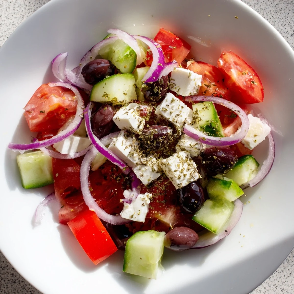 Mediterranean Salad with vibrant tomatoes, cucumbers, olives, and feta, beautifully presented for serving.