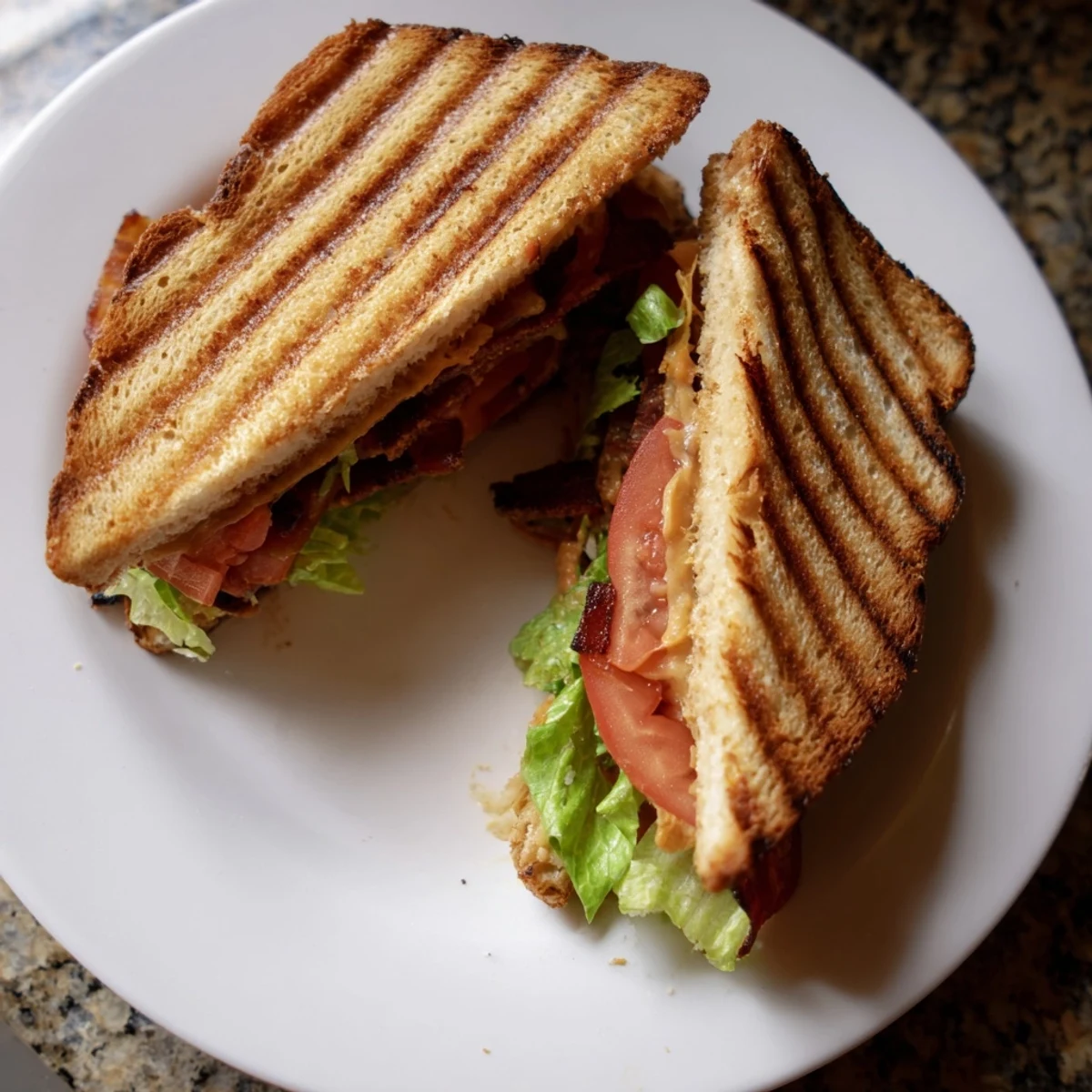 Golden-brown grilled sourdough sandwiches filled with smoky tempeh bacon, melted vegan cheese, fresh lettuce, and ripe tomato slices.