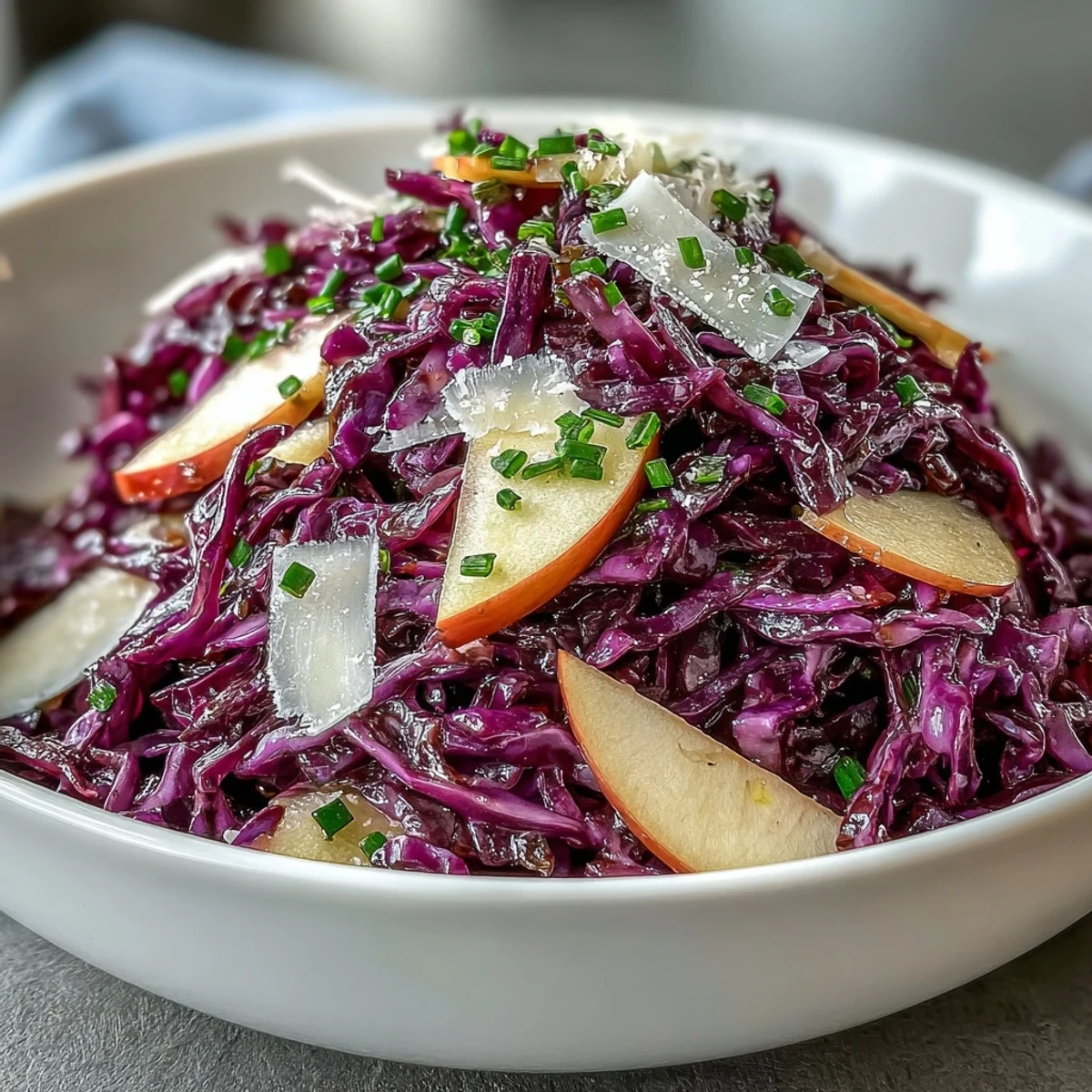 Freshly shredded red cabbage salad with crisp apple slices and shaved Parmesan, tossed in a tangy apple cider vinaigrette.