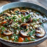 Savory Mushroom Barley Soup ladled into a white bowl, ready to be served hot.