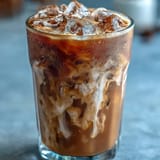 Iced brown sugar oat milk shaken espresso with a frothy top and cinnamon garnish