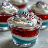 Red, white, and blue layered 4th of July Firecracker Jello Shots sparkle.