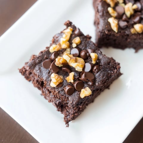 Fudgy Greek yogurt brownies, warm from the oven, with melting chocolate chips topping them.