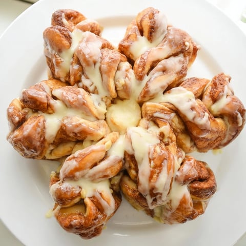 Golden, baked Cinnamon Roll Pull-Apart Snowflake with glistening icing, perfect for a cozy winter breakfast.