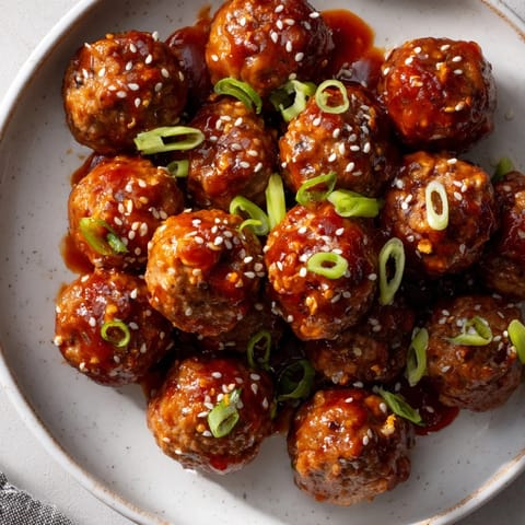 These delicious Spicy Sriracha Honey Meatballs are coated in a sweet and spicy sauce, ready to serve and enjoy.