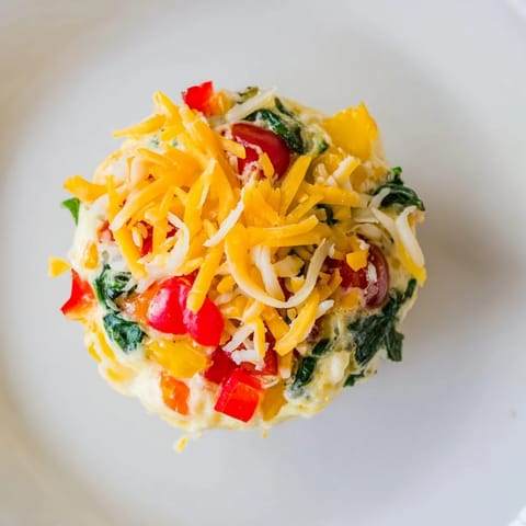 A close-up of steaming Customizable Egg Muffins shows the savory filling, ready to enjoy alongside your morning coffee.