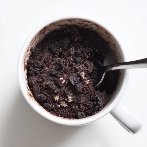 A close-up shot of a fluffy, chocolatey Oreo mug cake, ready to savor right from the mug.