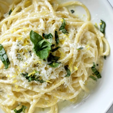 Freshly grated Parmesan and zesty lemon zest top warm lemon ricotta pasta tossed with olive oil and garlic.