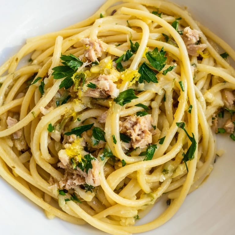 Close-up of al dente Lemon-Garlic Tuna Spaghetti, a simple pasta dish with parsley and zesty flavor.