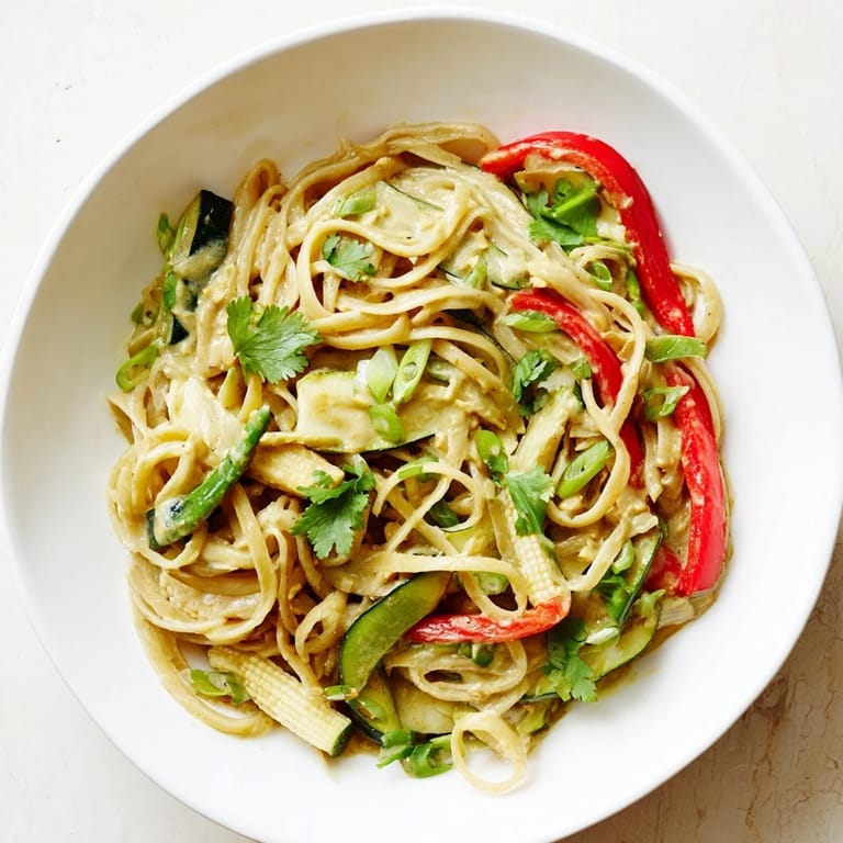 Aromatic, flavorful Thai Curry Pasta arranged in a bowl, garnished with fresh cilantro and a lime wedge.