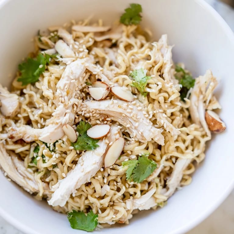 A refreshing bowl of American-Asian fusion salad, featuring bright greens, savory chicken, and a zesty homemade ginger-sesame vinaigrette.