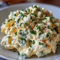A fluffy skillet of cottage cheese scrambled eggs with melted curds and golden edges, served hot for a protein-rich breakfast.